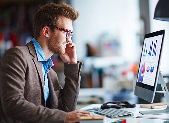 man on phone and computer at work