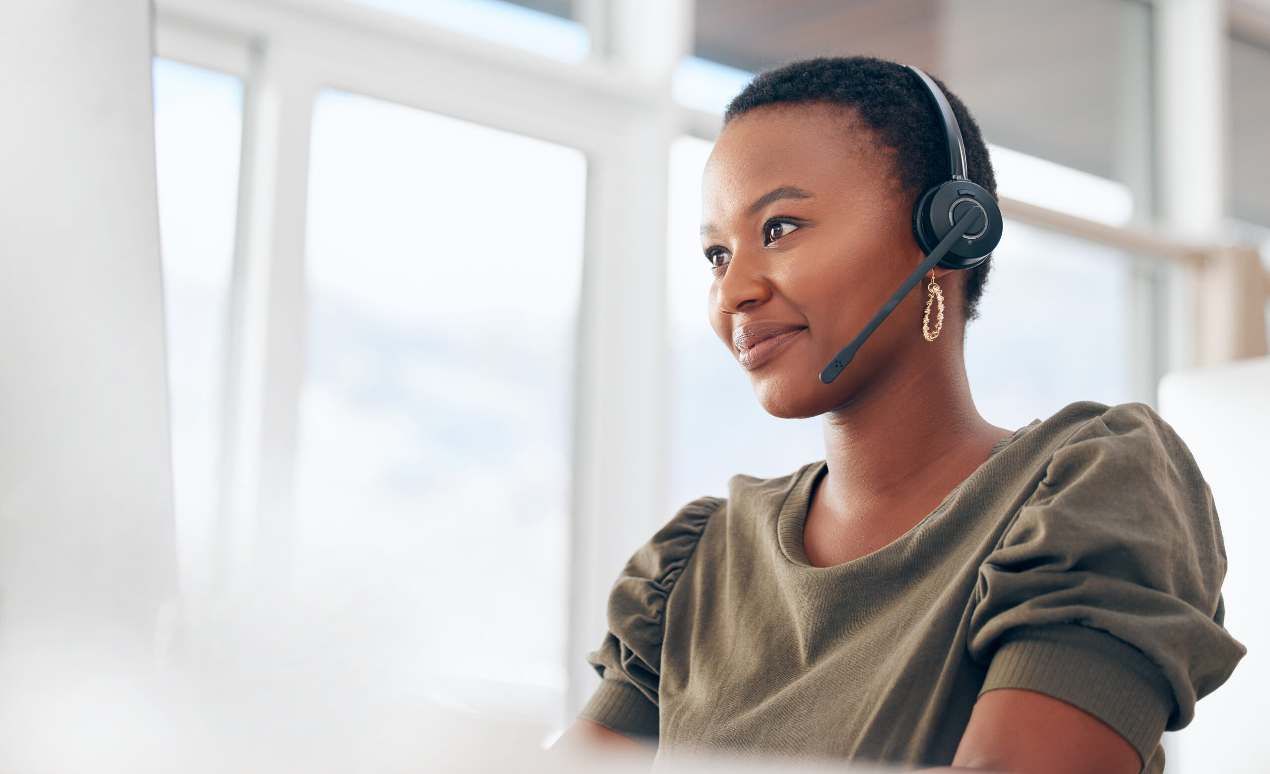 If you need us, call. Shot of a woman wearing a headset while working in a call centre.