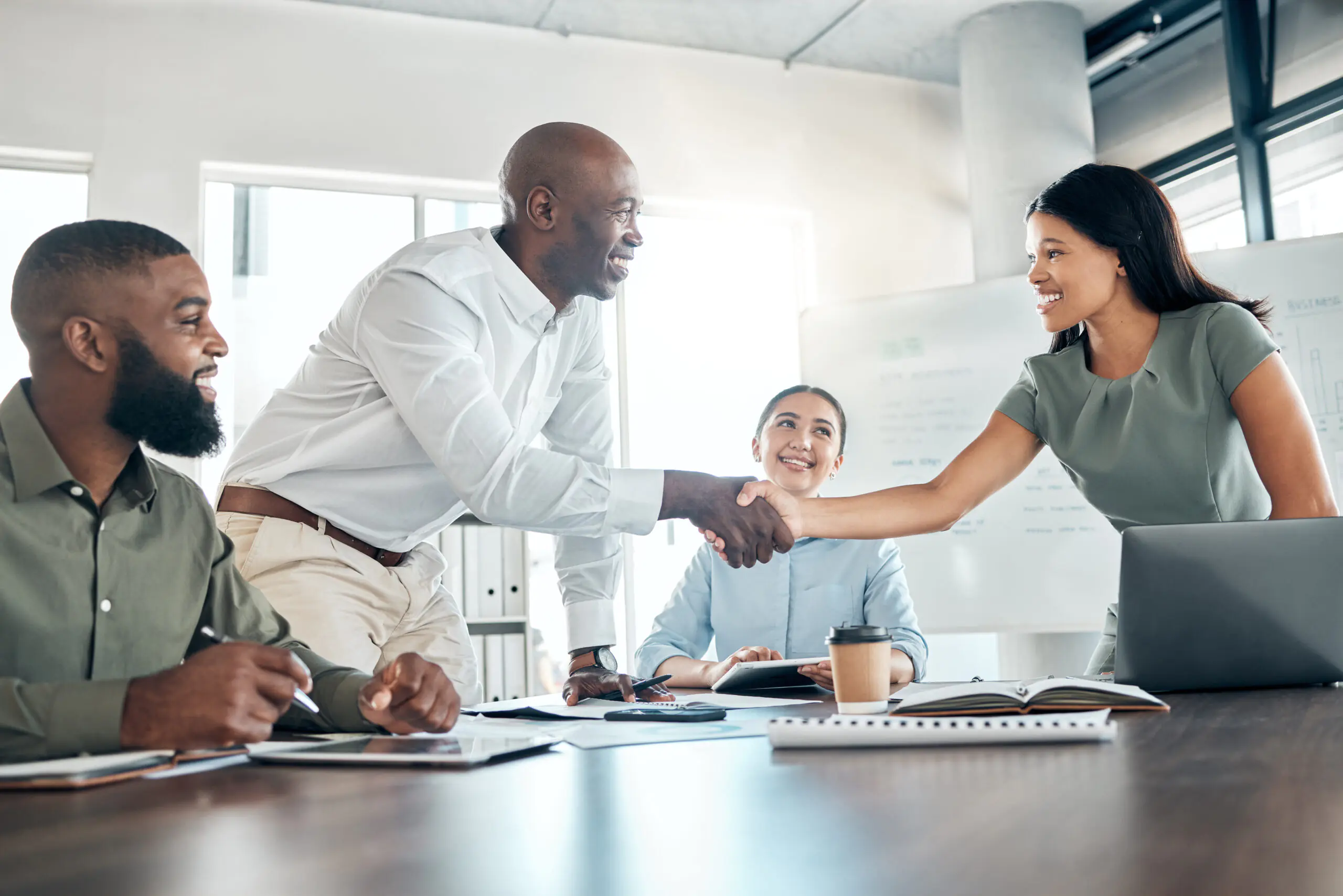 Handshake, office diversity and meeting welcome for company onboarding or partnership together. Introduction, agreement and negotiation with workforce people in corporate company boardroom.