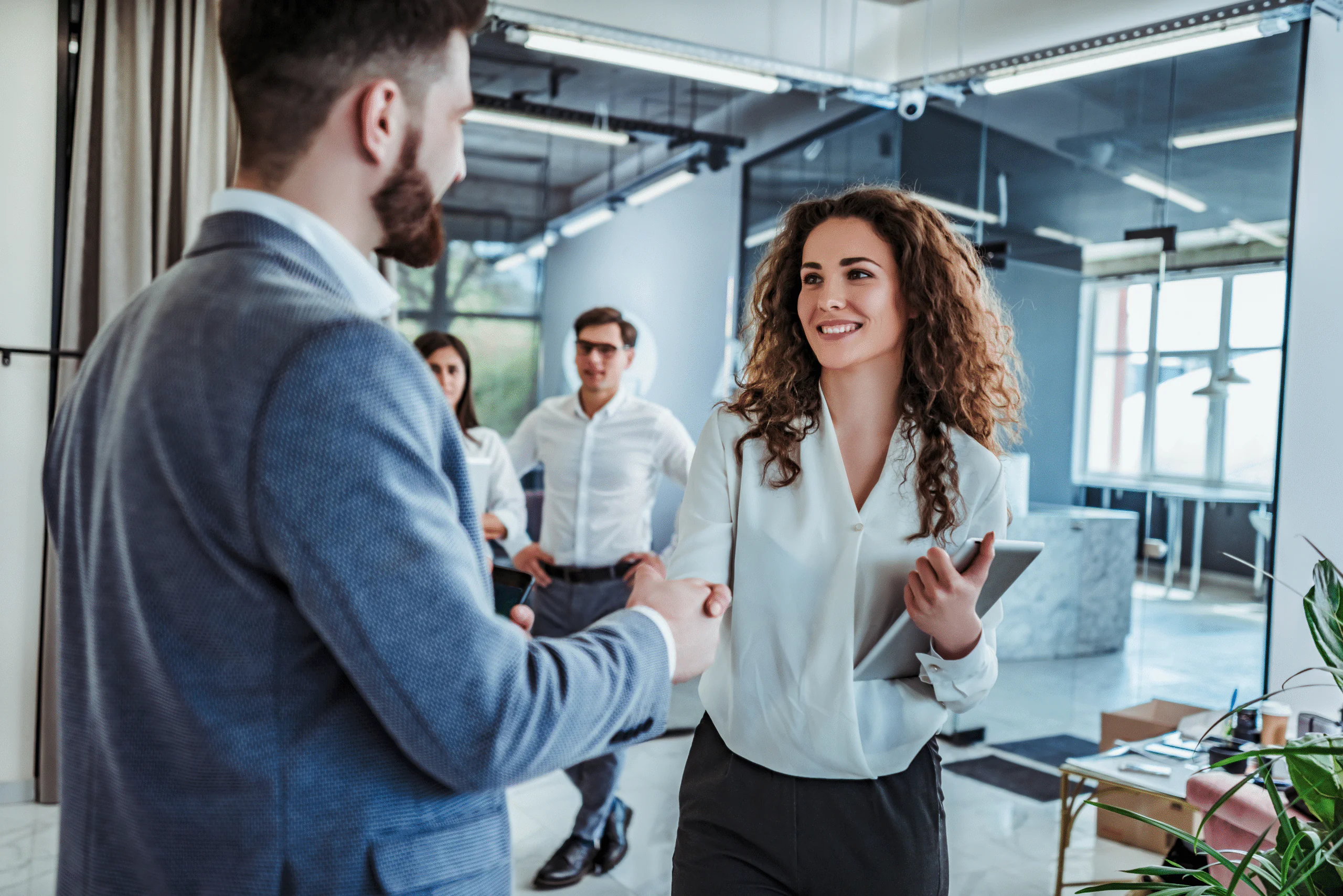 Man and woman are shaking hands in office